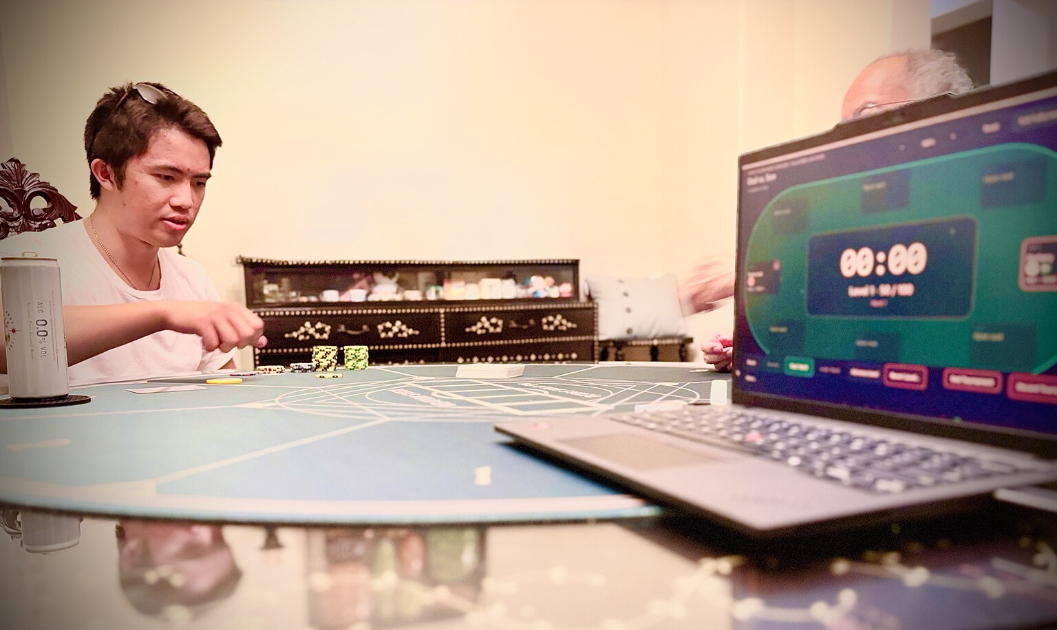Close-up of Poker Tournament Manager on a laptop operating beside the physical poker table during the event.