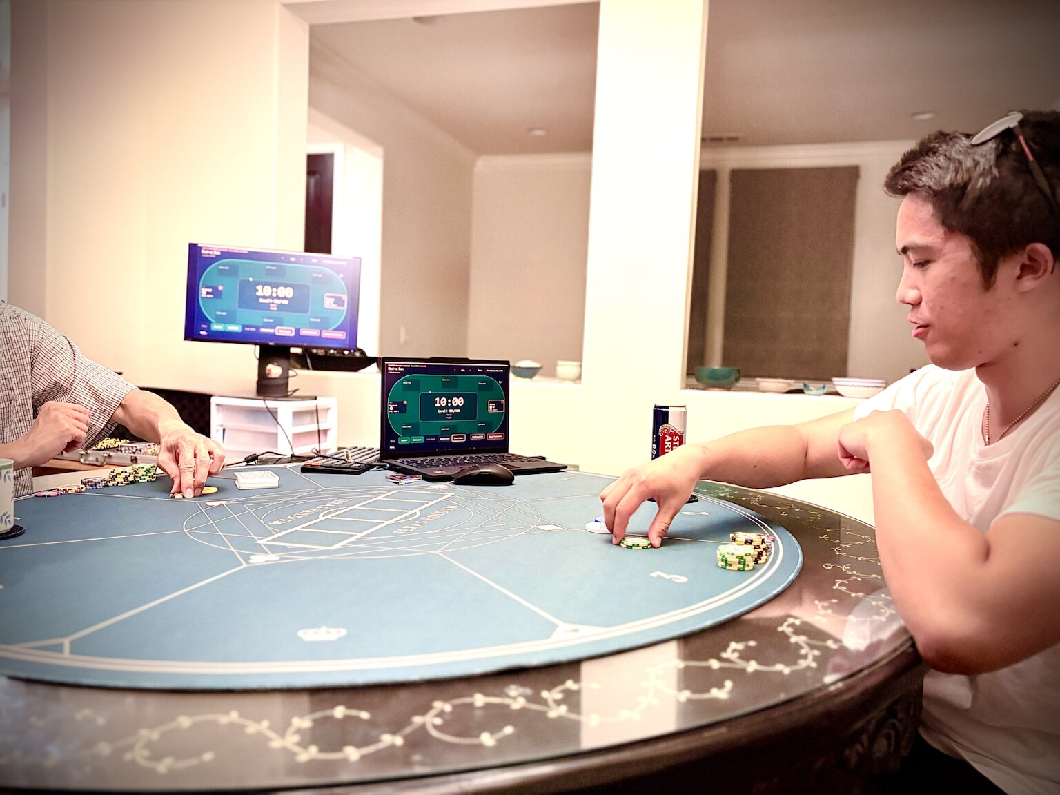 Poker Tournament Manager displayed on a laptop and external monitor while participants play at the physical poker table.